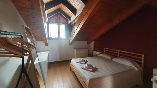 a bedroom with a large bed with a window at Appartamento Residenza Lavinia in Monforte dʼAlba