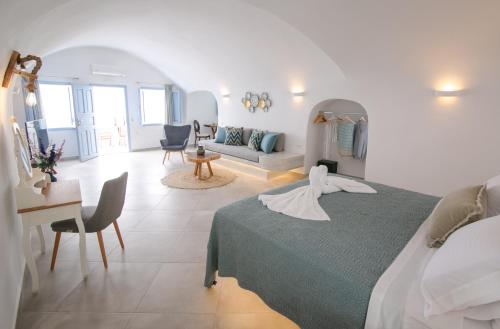 a bedroom with a bed and a living room at Sun Angelos Oia - Luxury Cave Suites in Oia