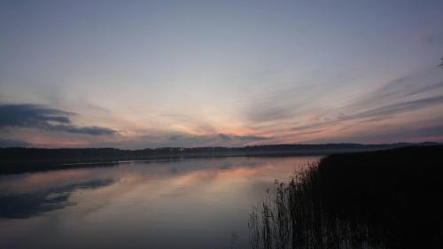 Blick auf einen Fluss mit Sonnenuntergang in der Unterkunft Lūšių vėjas in Palūšė