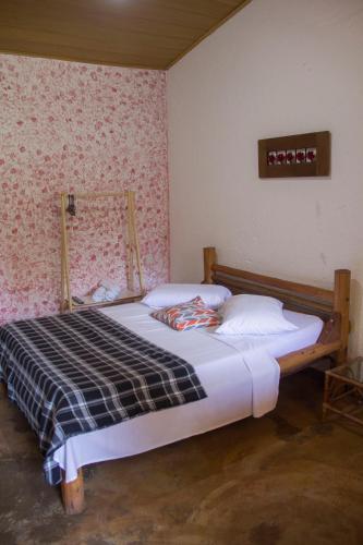 a bedroom with a bed in a room at Vila Flores Pousada in Serra do Cipo