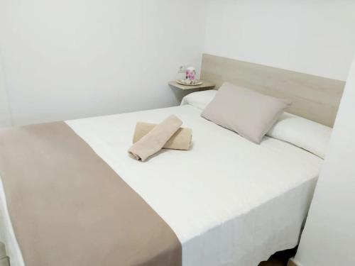 a white bed with two pillows on top of it at Apartament Bonaire in L'Escala