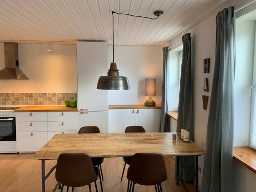 - une cuisine avec une table et des chaises en bois dans l'établissement 4 personers ferielejlighed, à Løkken