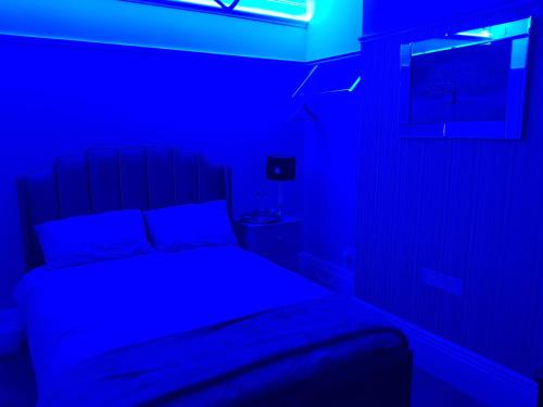 a bedroom with a bed with a blue light at Highfields Living - All Rooms Ensuite- Free Wifi- Free Local Parking in Sheffield