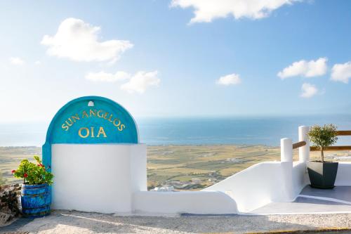 un edificio bianco con una cupola blu sopra di Sun Angelos Oia - Luxury Cave Suites a Oia