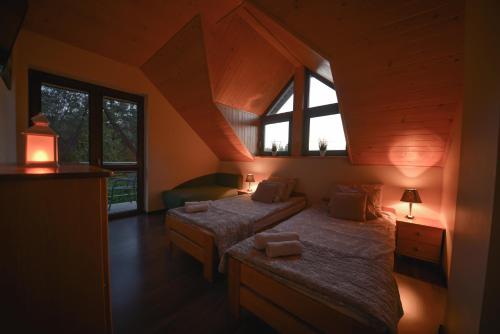 a bedroom with two beds and two windows at Agroturystyka Nad Stawem in Górno
