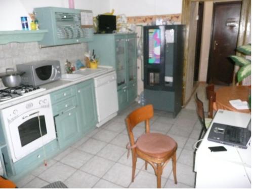 een keuken met groene kasten en een tafel en stoelen bij walter guest house in Rome