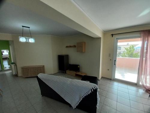 a living room with a couch and a large window at Treasure star B&b in Salamís