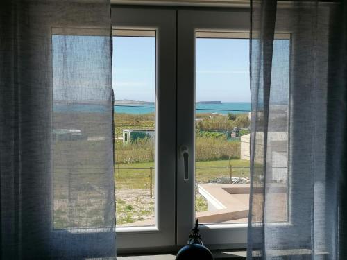 a window with a view of the ocean through it at Baleal Atlantic View House in Baleal