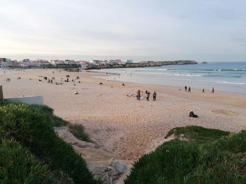 a group of people on a beach near the ocean at Baleal Atlantic View House in Baleal