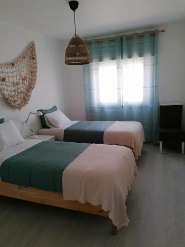 a bedroom with two beds and a couch at Baleal Atlantic View House in Baleal