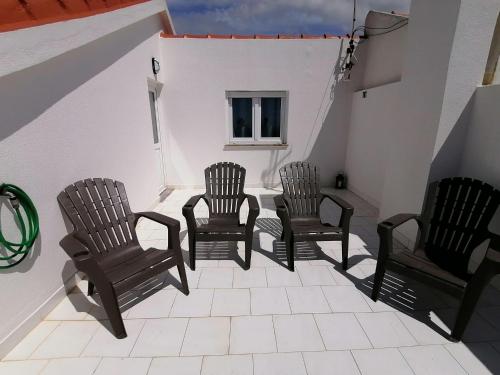 a group of chairs sitting on a porch at Baleal Atlantic View House in Baleal