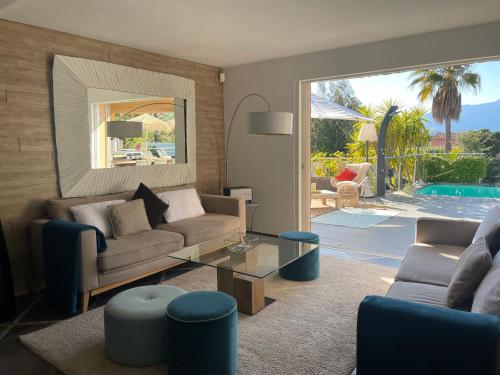 - un salon avec un canapé, une table et une piscine dans l'établissement Villa CASA BAGGIA, proche plage, piscine à débordement chauffée, pool house, à Porto-Vecchio