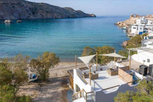 Blick auf einen Strand mit weißen Gebäuden und das Wasser in der Unterkunft Vilos Suites Fyropotamos Beach in Firopótamos