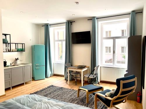 1 dormitorio con nevera azul, mesa y sillas en Vintage Chic Studio - by Nahuen Suites, en Graz