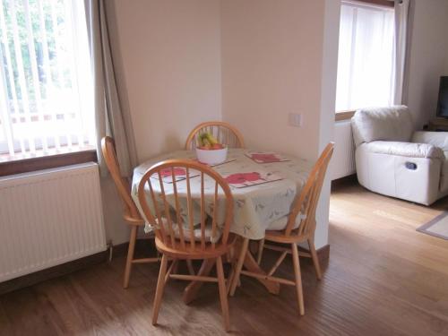 a dining room with a table and chairs and a couch at Easter Bowhouse Farm Cottage in Linlithgow