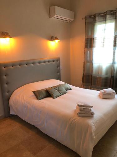 une chambre avec un grand lit blanc avec deux oreillers dans l'établissement Green village, à Roquebrune-sur Argens