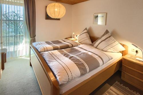 a bedroom with a large bed with a window at Haus Ulrike-Maria in Badenweiler