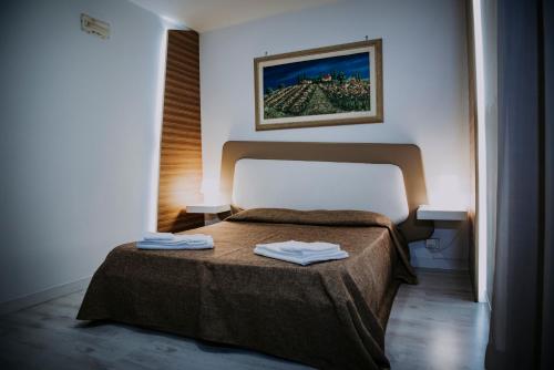 ビアンカヴィッラにあるHotel Casale dei Greciのベッドルーム1室(ベッド1台、タオル2枚付)