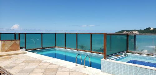 a swimming pool with a view of the ocean at Araça Flat Natal Prime - Beira Mar in Natal