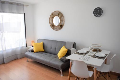 salon z kanapą i stołem w obiekcie La Casita del Sol w Corralejo