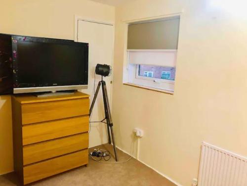 einen Fernseher auf einer Kommode mit Kamera drauf in der Unterkunft Private room 4-5 minutes drive to Luton Airport in Luton