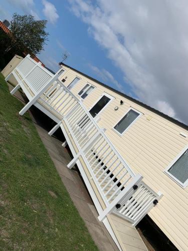 Seton Sands Haven Holiday Park - Platinum Caravan في Prestonpans: منزل فيه سلم ابيض جنبه