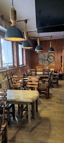 un restaurante con mesas de madera, sillas y luces en Penzion KASPEC, en Uničov