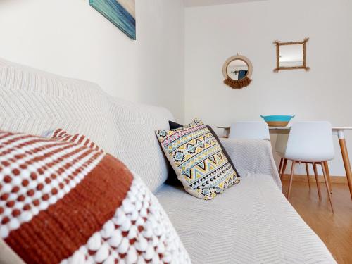 a white couch with a pillow and a table at Casa Ledù - Sunny Holiday in Fuerteventura in Corralejo