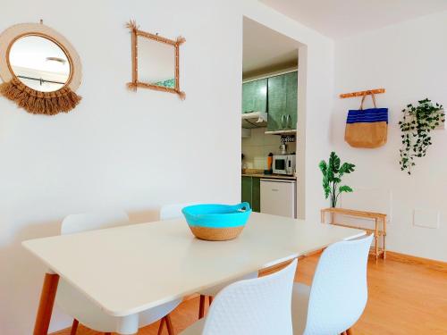 mesa de comedor blanca con sillas blancas y espejo en Casa Ledù - Sunny Holiday in Fuerteventura, en Corralejo