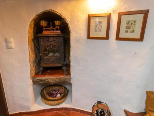 a wood stove in a wall with two pictures at Moinho Monte Adão in Vila Franca do Rosário