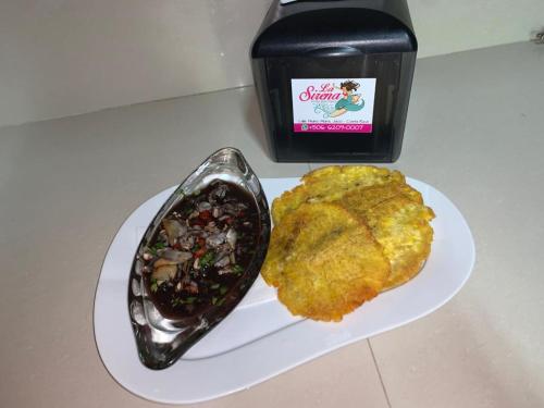 a white plate with a meal of food and sauce at La Sirena Playa Jacó in Jacó
