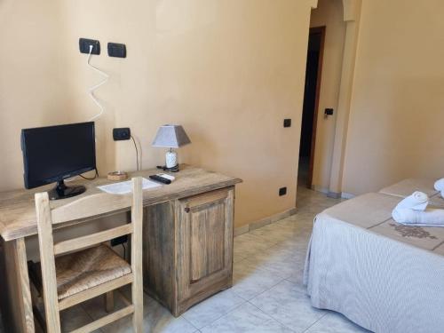 a bedroom with a desk with a computer and a bed at Hotel Plammas in Santa Maria Navarrese