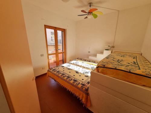 サンタ・テレーザ・ガッルーラにあるLa stella rosa sul mareのベッドルーム1室(ベッド1台、シーリングファン付)