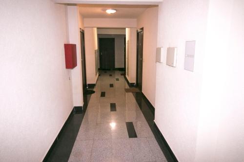 a hallway of a building with white walls and tile floors at Apartment Nova Otoka in Sarajevo