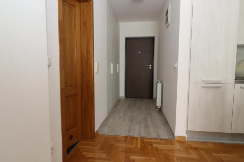 korytarz z drzwiami i drewnianą podłogą w obiekcie Apartment Nova Otoka w Sarajewie