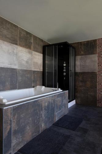 une grande salle de bain avec baignoire et douche dans l'établissement Le New-York Spa, à Saint-Étienne
