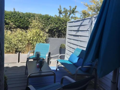 two blue chairs and chairs on a patio at Bord Verdon T2 Maisonnette 35m2 Climatisation - Terrasse 25m2-classé 3étoiles in Gréoux-les-Bains