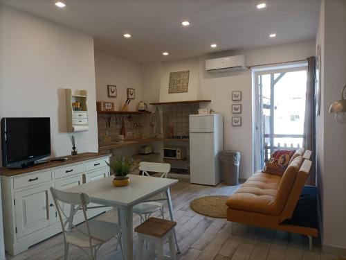 a living room with a table and a kitchen at Amelia Apts & Rooms in Alghero