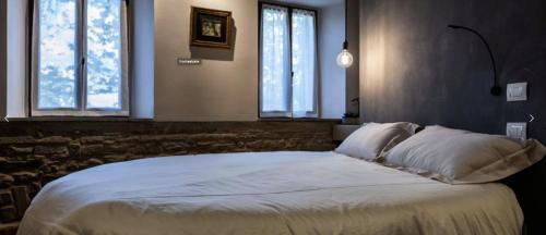1 dormitorio con 1 cama blanca grande y 2 ventanas en B&B Fonteabate Residenza di Charme, en Bagno di Romagna