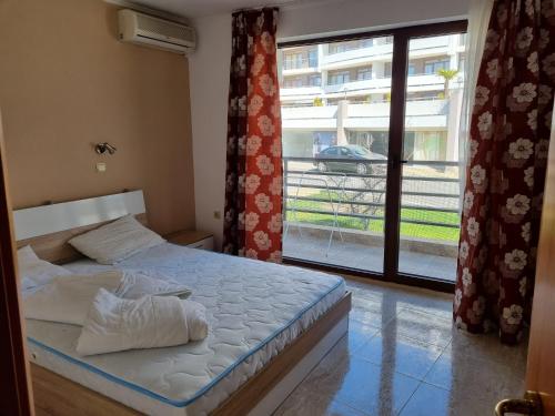 ein Schlafzimmer mit einem Bett und einem großen Fenster in der Unterkunft Luxsus Apartment Diamond Sveti Vlas in Sweti Wlas