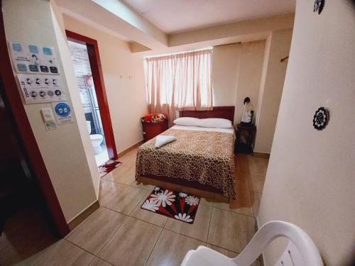 a small bedroom with a bed and a window at Hostal Oro Orense in Quito