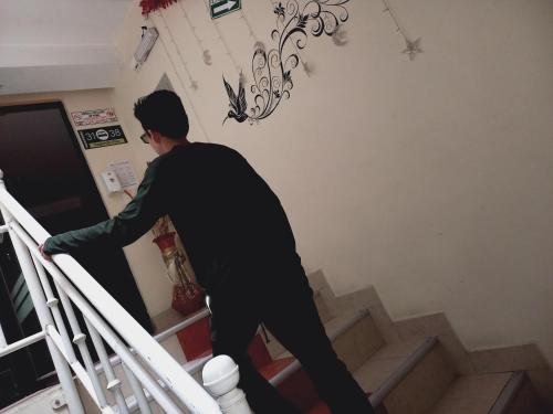 a man walking down the stairs of a house at Hostal Oro Orense in Quito