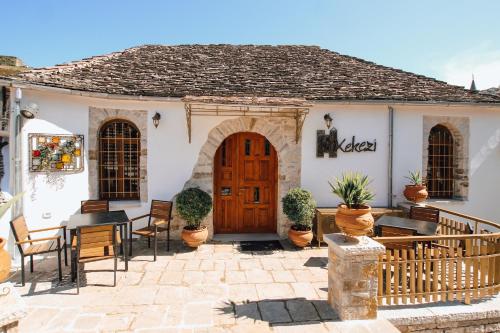 a house with a wooden door and a patio at Hotel SS KEKEZI in Gjirokastër