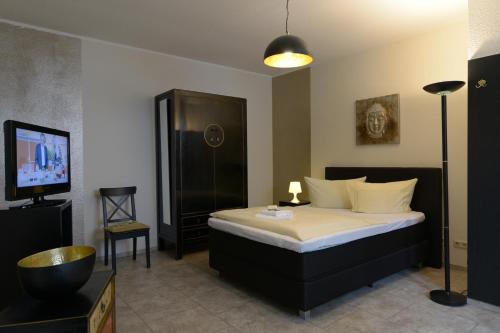 a hotel room with a bed and a television at Hotel-Pension Mandy - Adults Only in Senftenberg