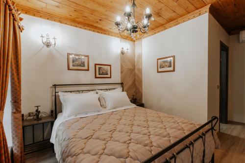 1 dormitorio con cama y techo de madera en Hotel SS KEKEZI en Gjirokastër