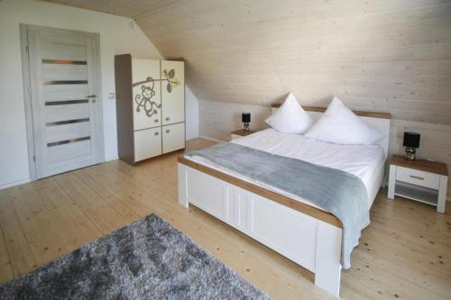 a bedroom with a large white bed and wooden walls at Holiday VIP complex in Wartowo by Kolczewo for 6 persons in Kołczewo