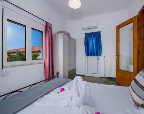 1 dormitorio con 1 cama con sábanas blancas y ventana en Plaka House, en Plaka