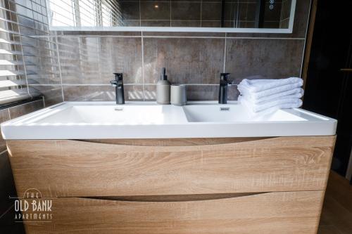 a white sink in a bathroom with a mirror at The Old Bank Apartments in Blackpool