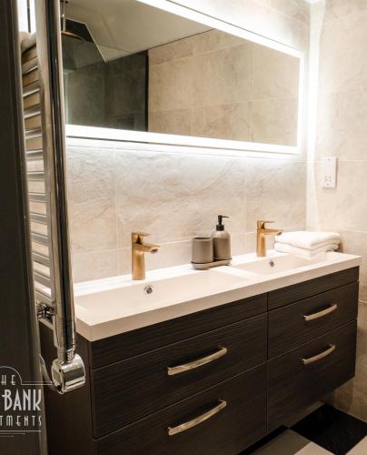 a bathroom with a sink and a mirror at The Old Bank Apartments in Blackpool