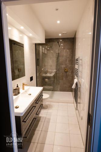 a bathroom with a shower and a toilet and a sink at The Old Bank Apartments in Blackpool